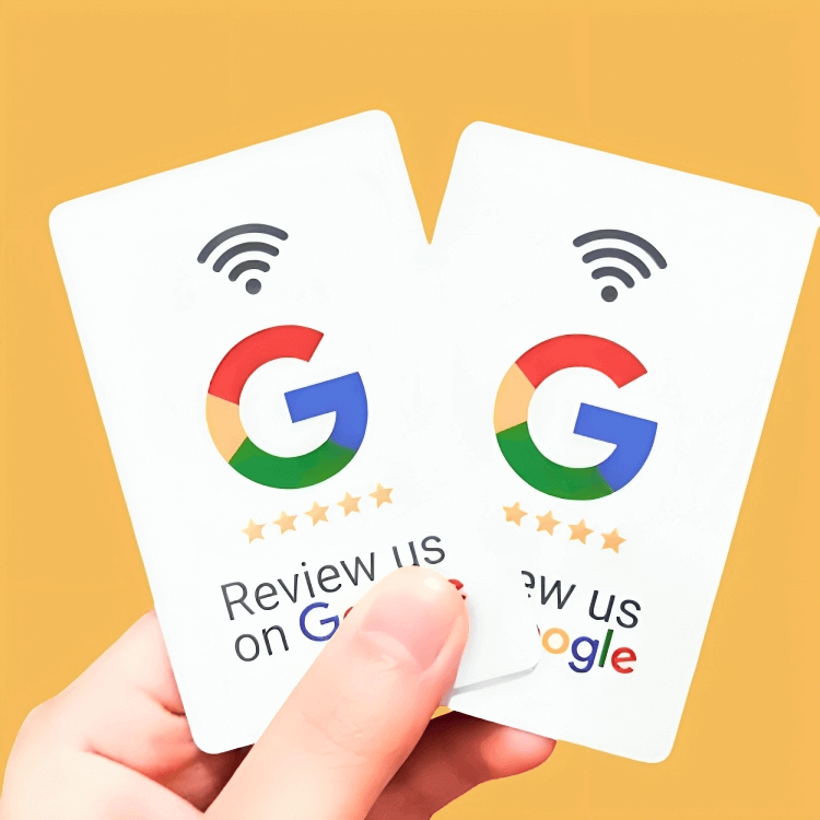 Mano sosteniendo dos tarjetas NFC para reseñas, con un mensaje que invita a escribir una reseña